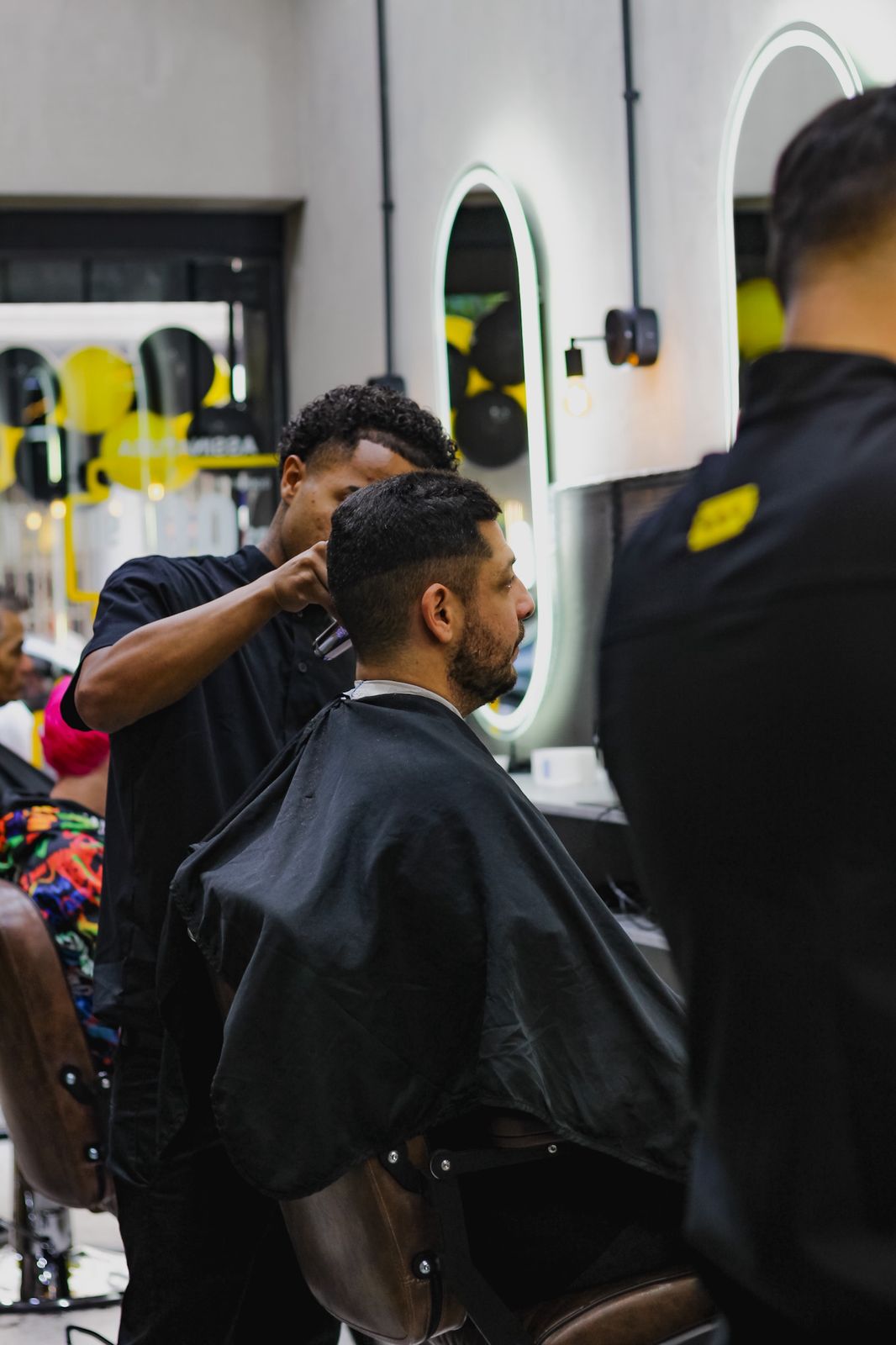 Barbeiro da equipe Navalha Sampa cortando o cabelo de um cliente